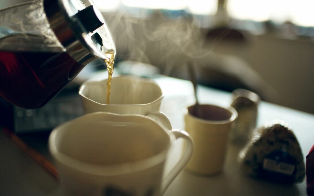 Cozy Tea Time: Warm Steaming Cup Scene Wallpaper Background