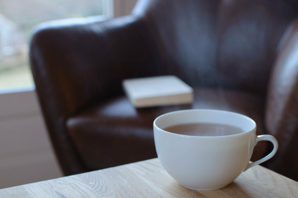 Cozy Tea Time: Warm Mug & Book in Inviting Atmosphere Wallpaper