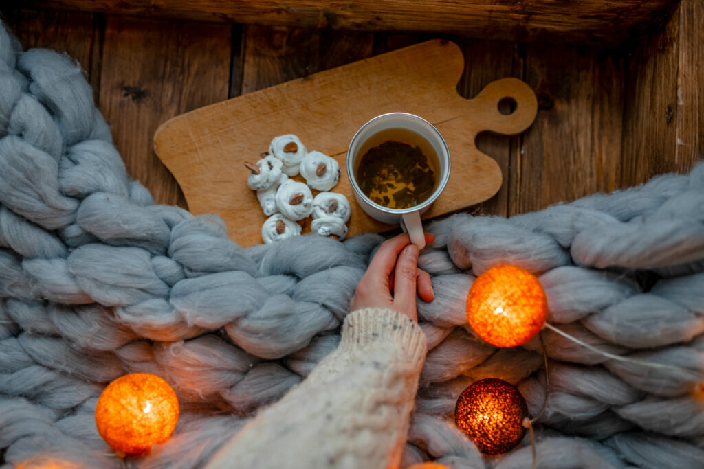 Cozy Tea and Sweets Scene with Warm Garlands - Wallpaper Background