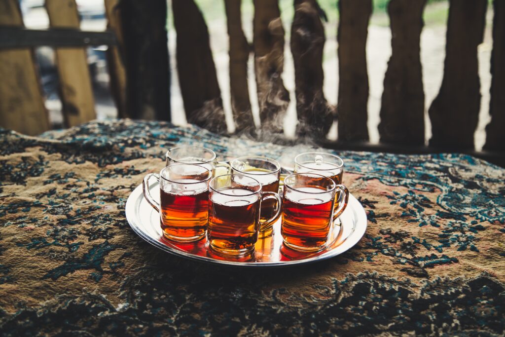 Steaming Tea Glasses on Patterned Fabric: Warm Atmosphere Wallpaper