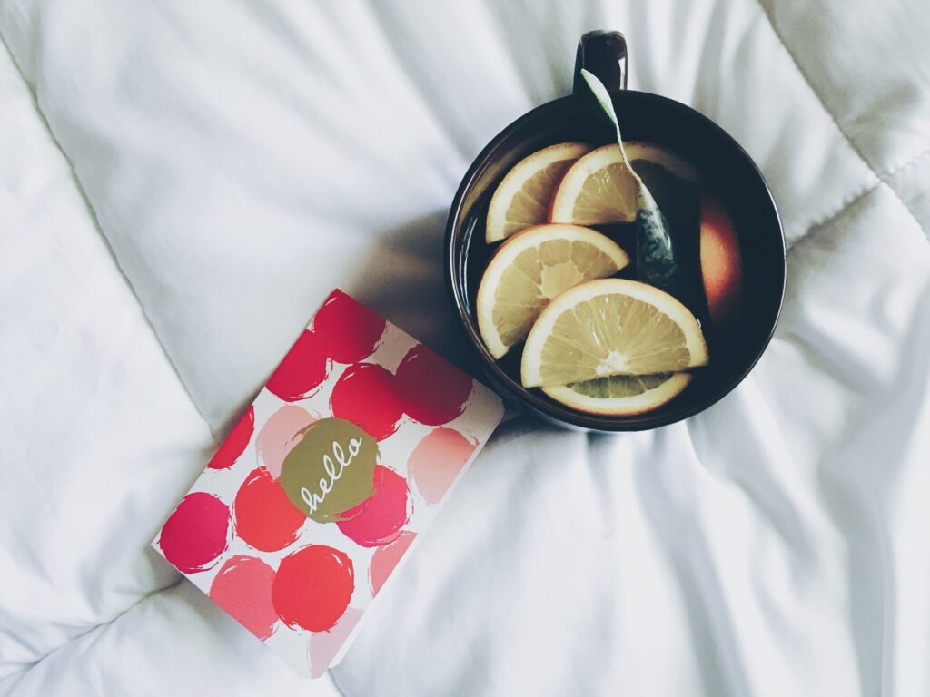 Cozy Tea Wallpaper: Black Cup & Lemon on Soft White Surface