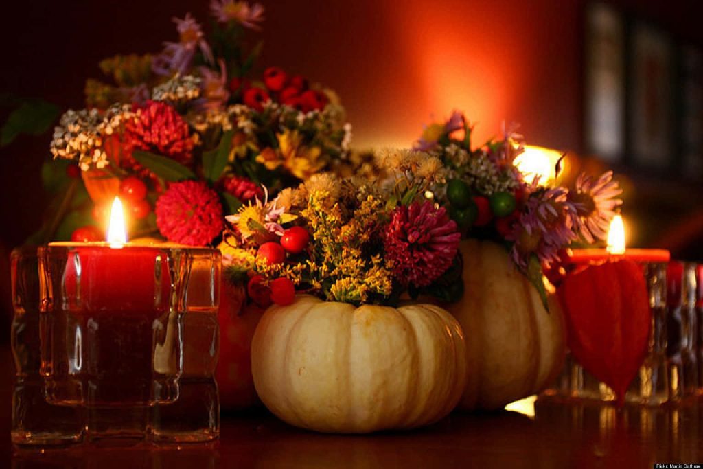 Thanksgiving centerpiece with autumn flowers in pumpkins glowing warm candlelight cozy decor Wallpaper