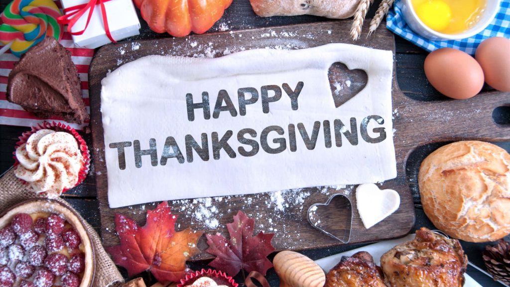 Festive Thanksgiving wallpaper overhead spread with Happy Thanksgiving dough board fall leaves food