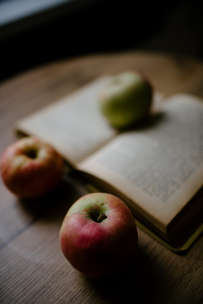 Cozy Apple Wallpaper: Warm Red & Green Decor with Open Book Setting