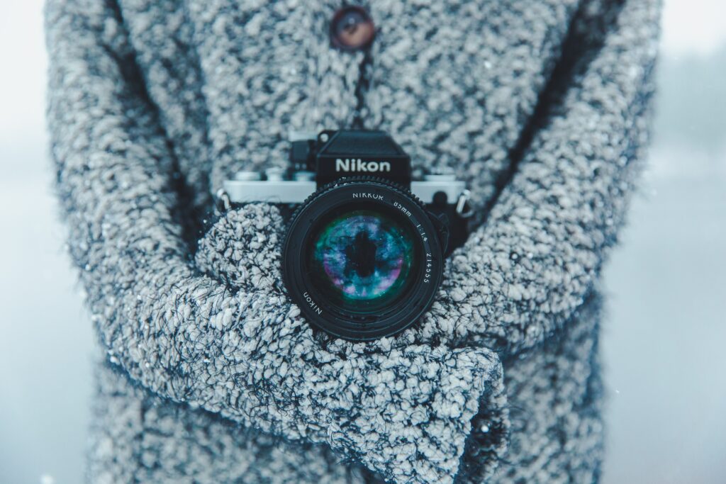 Cozy Winter Scene: Photographer in Gray Jacket Captures Snowy Bliss Wallpaper