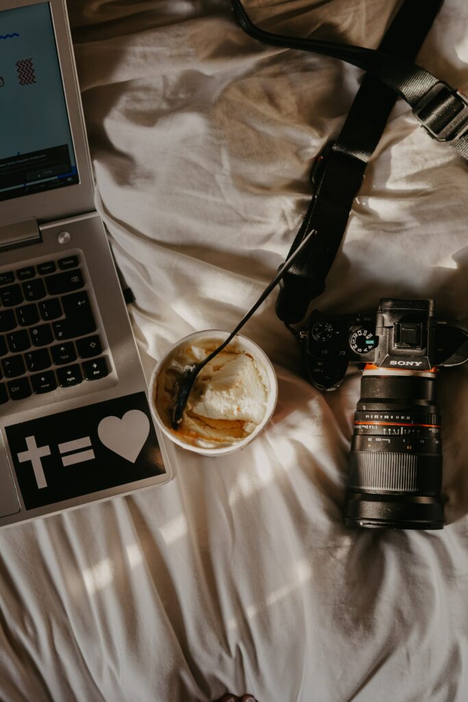 Cozy Workspace: Laptop, Camera & Delicious Ice Cream Delight Wallpaper