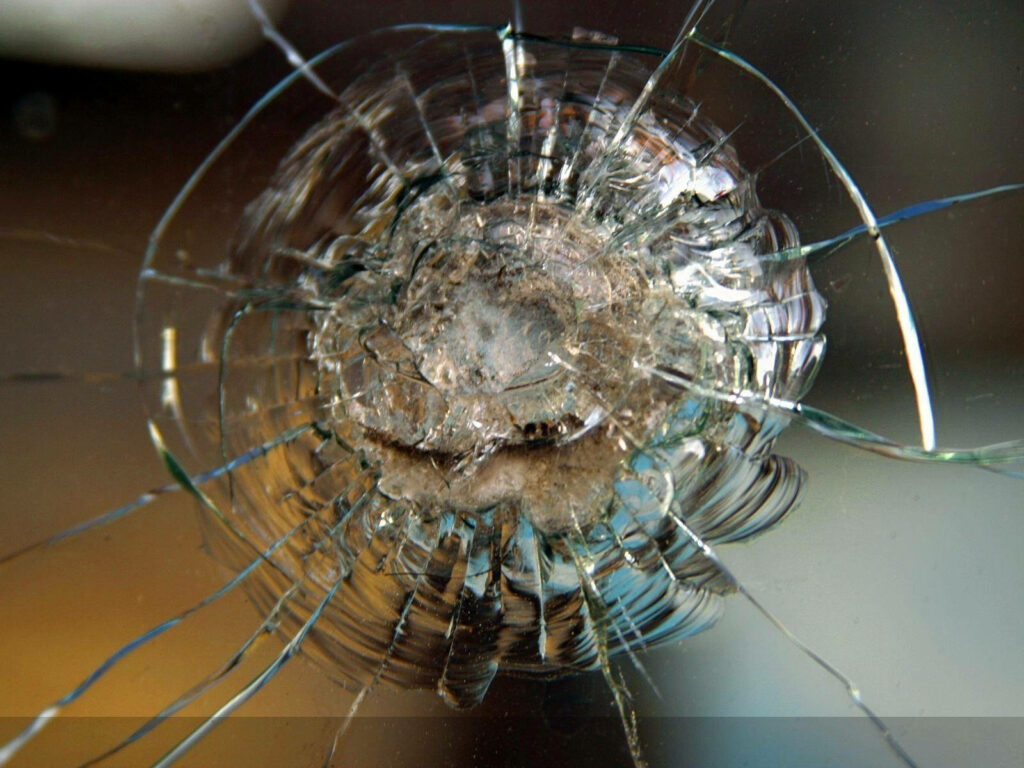 High-resolution cracked computer screen wallpaper with detailed shattered glass and central impact