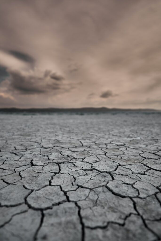Cracked desert landscape wallpaper with dramatic cloudy sky showcasing dry earth and drought