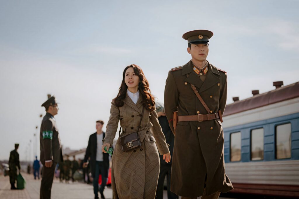 Yoon Se-ri and Ri Jeong-hyeok in vintage attire walk at train station Crash Landing On You romance Wallpaper