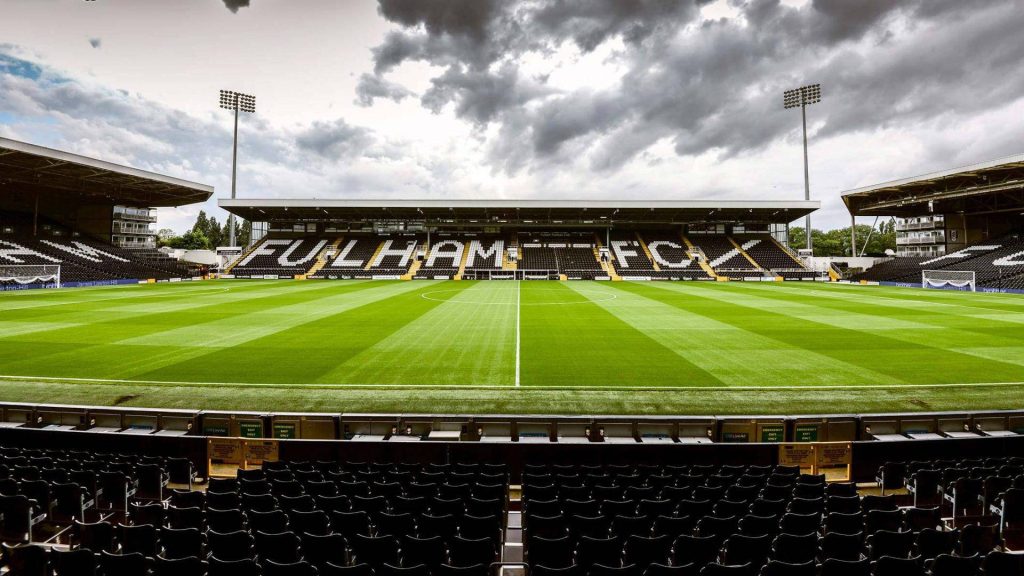 Craven Cottage stadium Fulham FC pristine pitch and seats under dramatic cloudy sky wallpaper