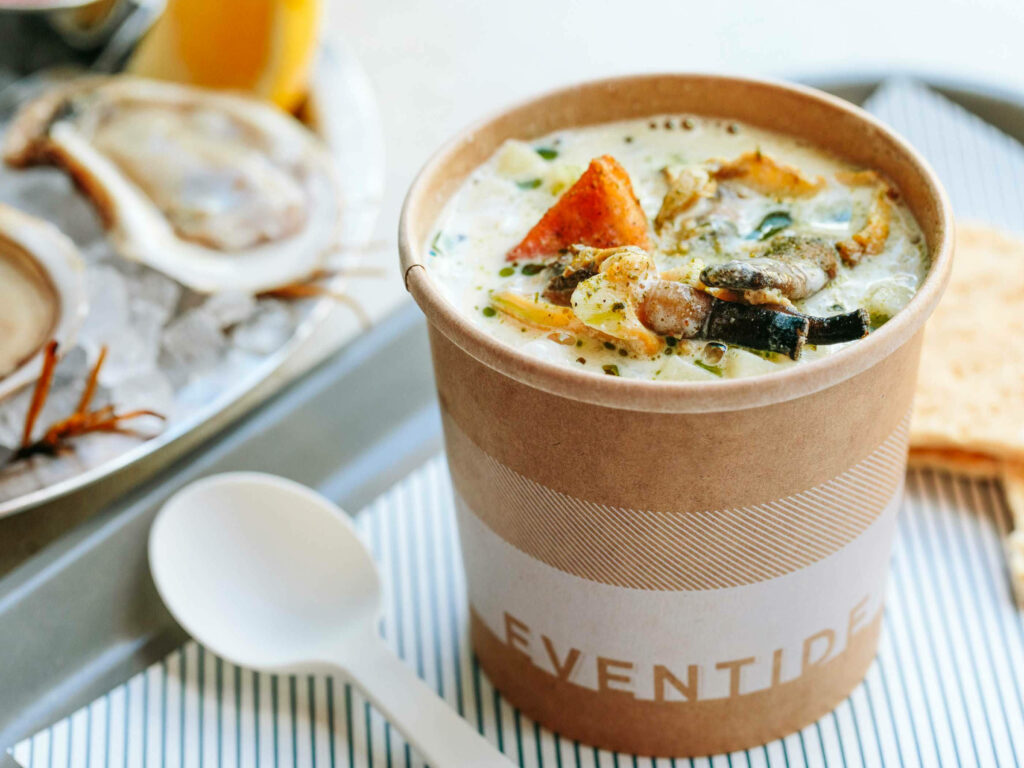 Creamy Boston style clam chowder with potatoes and herbs in rustic cup with warm natural light Wallpaper