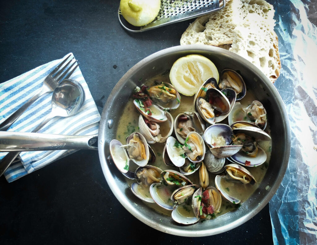 Overhead view of creamy English chowder with mussels clams fresh herbs rustic bread and lemon Wallpaper
