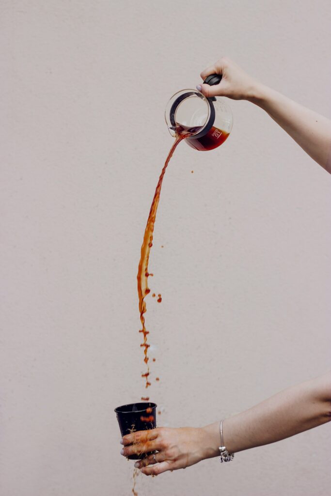 Creative Coffee Pour Wallpaper: Splashing Art on Neutral Background
