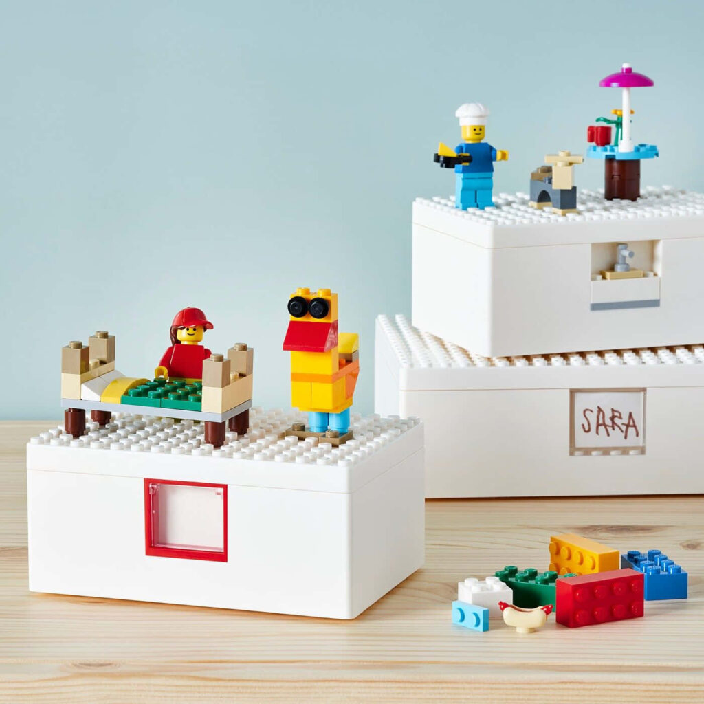 Colorful Lego figures and miniature scenes on white storage boxes in a bright playful setting Wallpaper