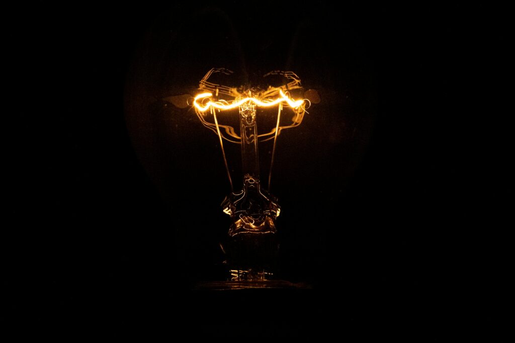 Glowing Light Bulb Wallpaper: Creativity Amidst Darkness