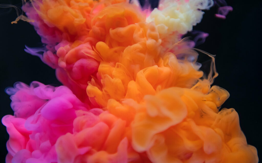 Vibrant 4K macro swirl of colorful pink orange yellow plumes on black abstract wallpaper background