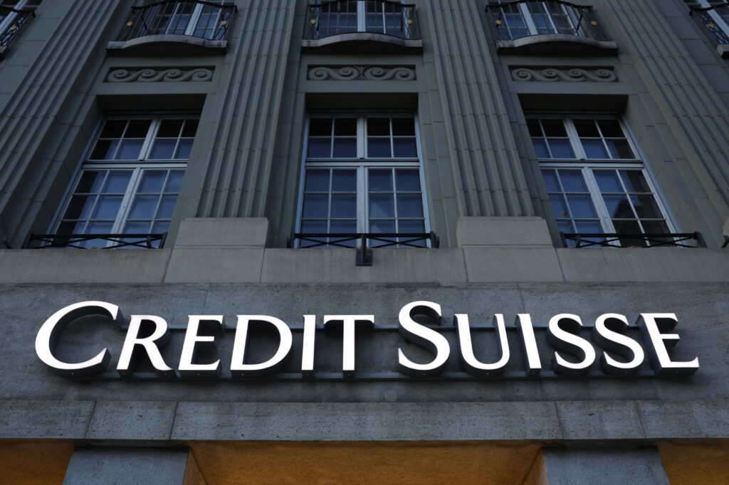 Illuminated Credit Suisse logo on classical building with columns and tall windows in grey tones Wallpaper