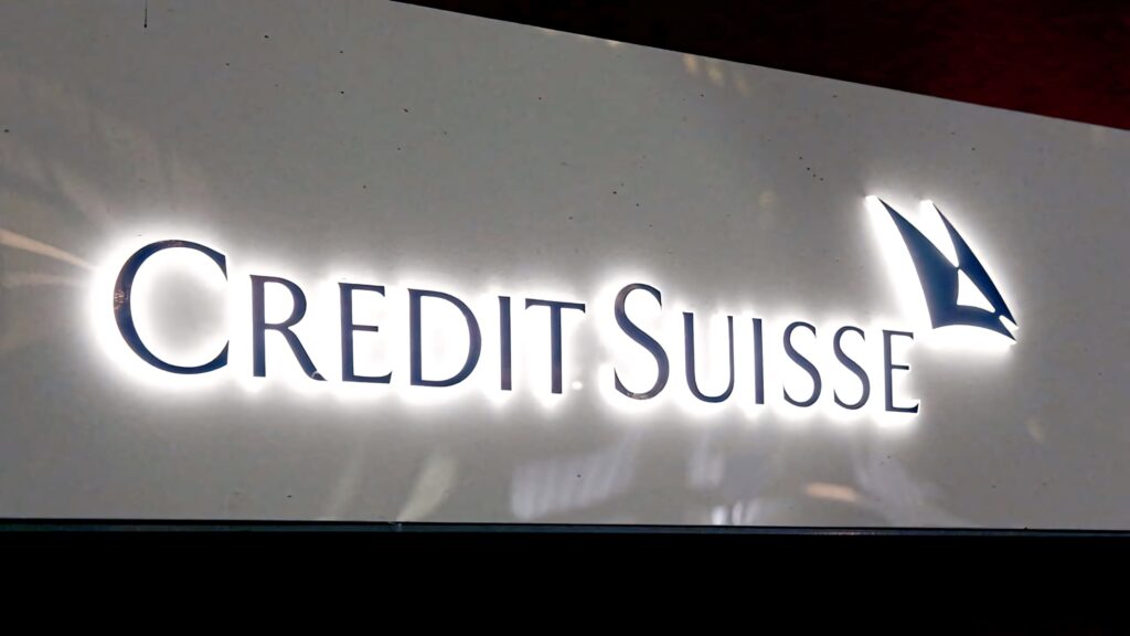 Illuminated Credit Suisse logo with blue lettering and sail emblem on sleek white background wallpaper