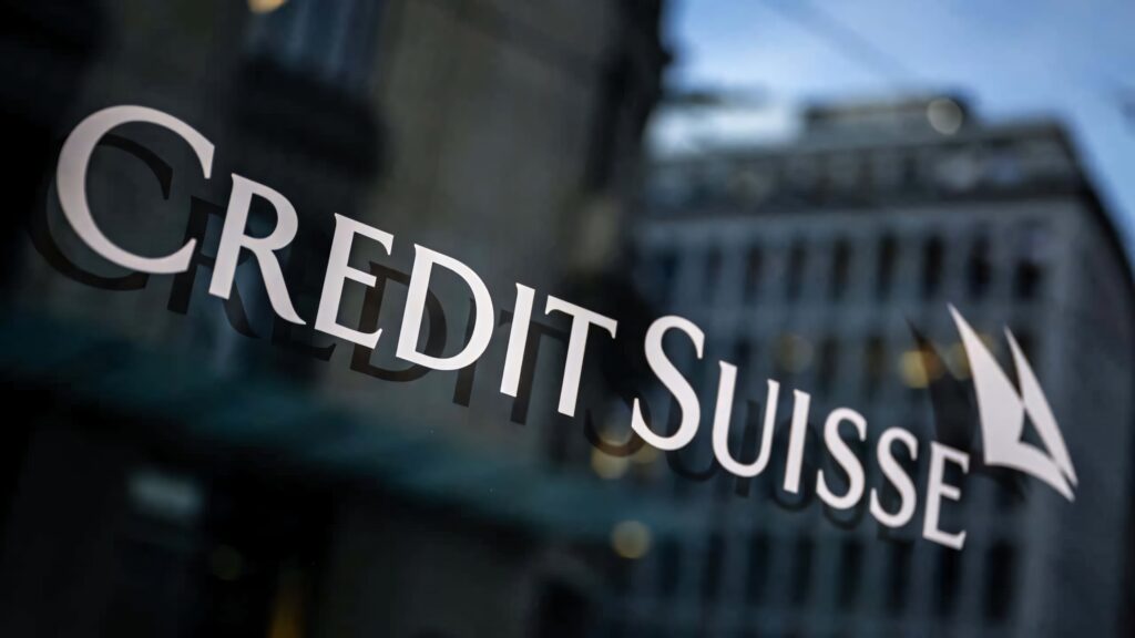 Credit Suisse logo on reflective glass with blurred modern cityscape financial background Wallpaper