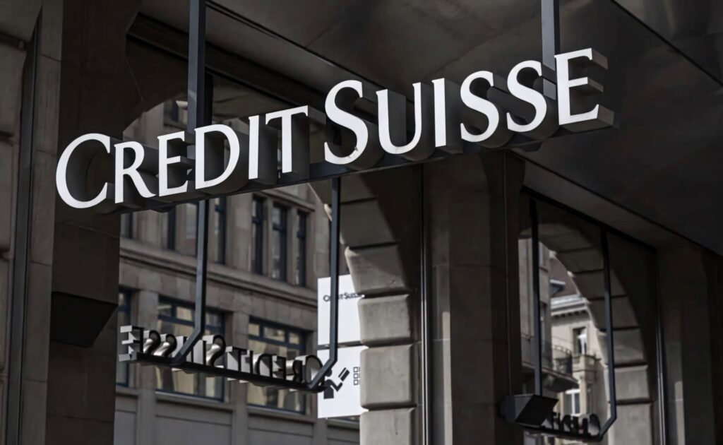 Credit Suisse silver logo on glass stone building facade with sharp reflections urban architecture Wallpaper