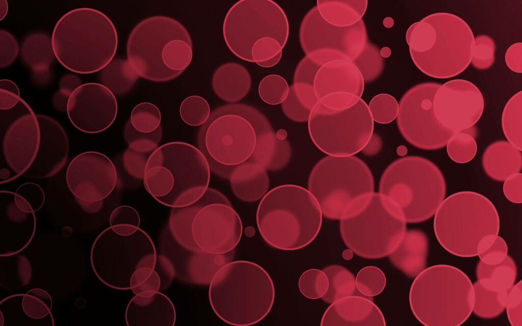 Crimson Circular Convergence: A striking wallpaper of red circle formations resembling blood cells against a dramatic black backdrop
