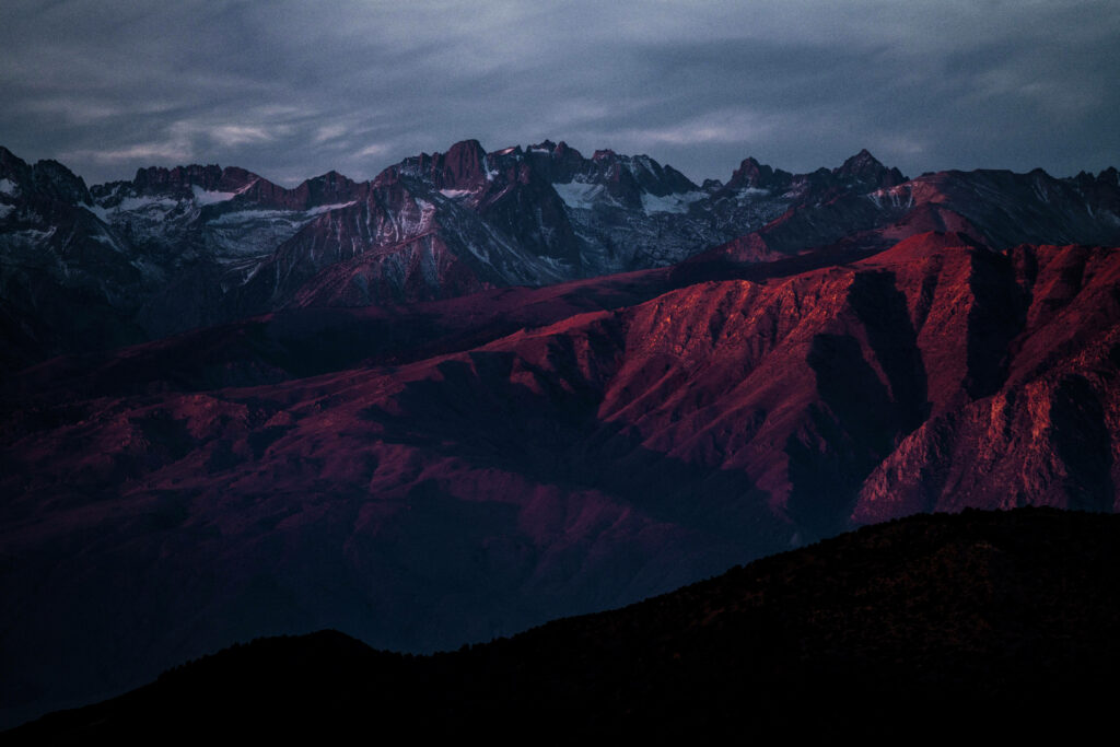Crimson Peaks Under Overcast Skies: A Striking Macos Wallpaper