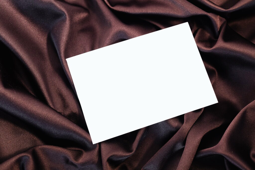 Contrasting Textures: Elegant Paper Resting on Warm Textile - High-definition Wallpaper