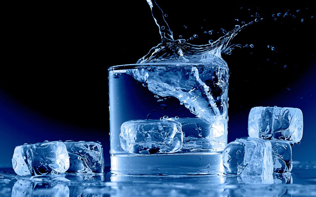 High-speed photo of ice splash in water glass with deep blue background dynamic wallpaper