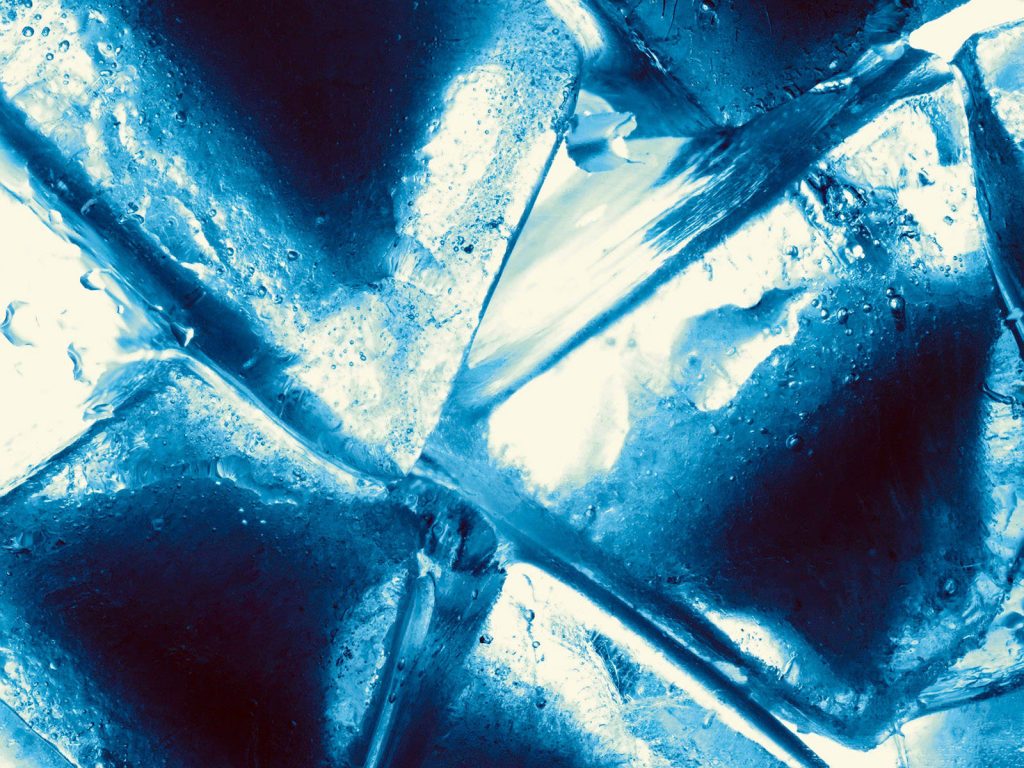 Macro close-up of jagged ice cubes with white and blue light highlighting translucent textures Wallpaper