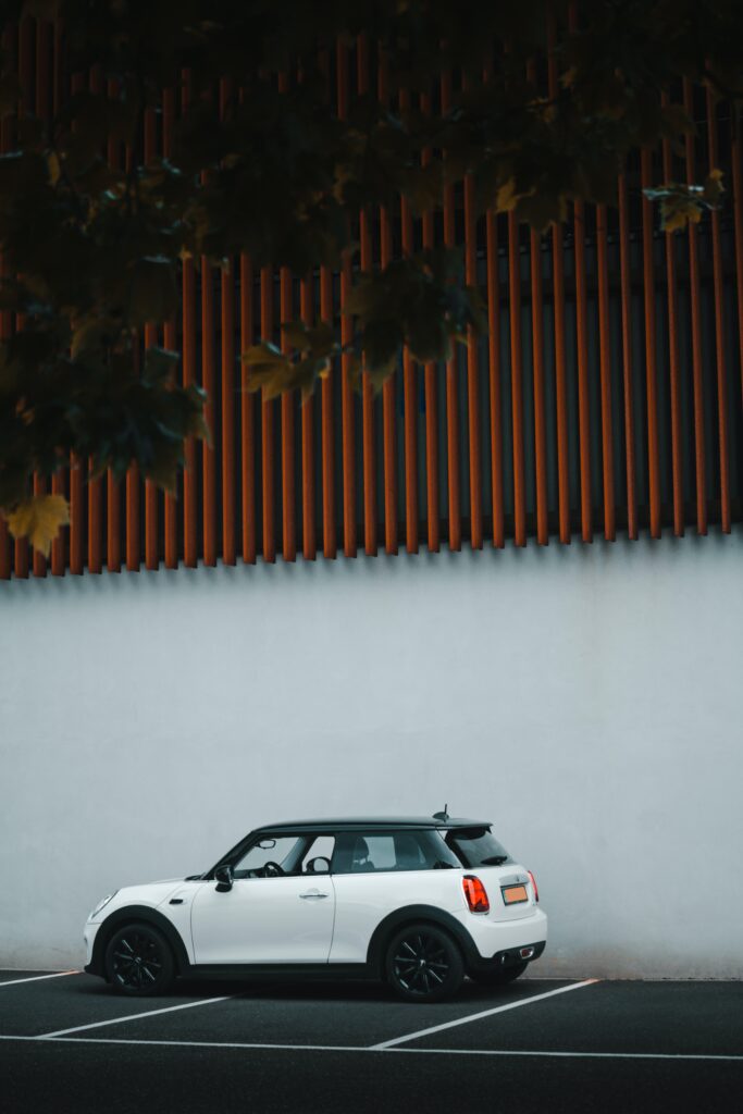 Stylish White Mini Cooper Against Textured Wall - Minimalist Wallpaper