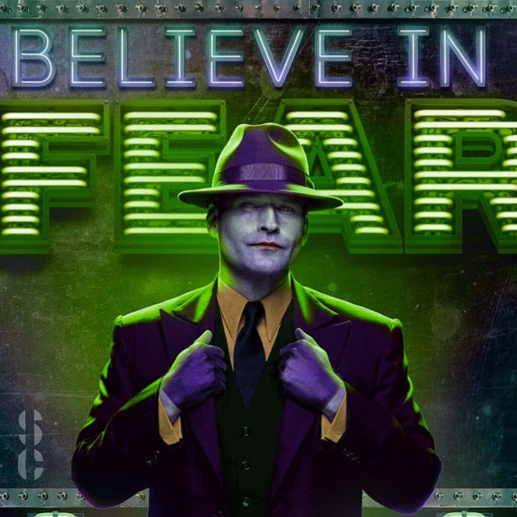 Crispin Glover in purple suit and fedora with neon green lighting and Believe In Fear sign wallpaper