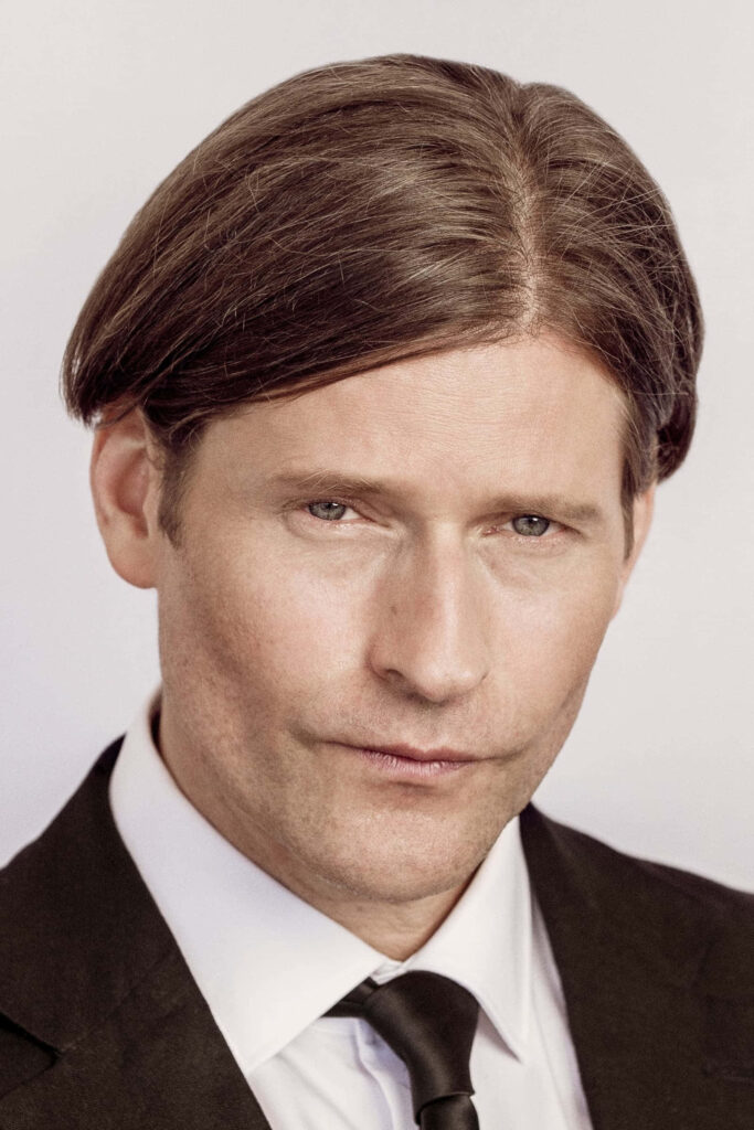 Crispin Glover sharp black suit intense gaze distinctive hairstyle high resolution portrait wallpaper