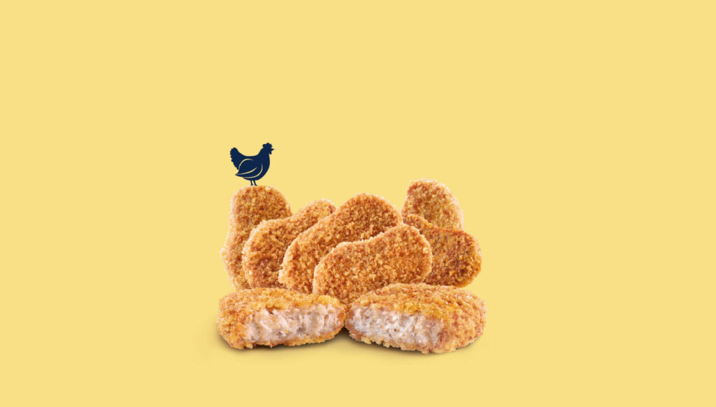 Crispy chicken nuggets pile on yellow background with small chicken silhouette playful wallpaper