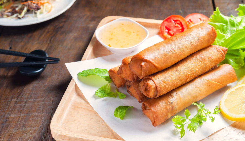 Crispy Golden-Brown Spring Rolls with Tangy Sauce Wallpaper