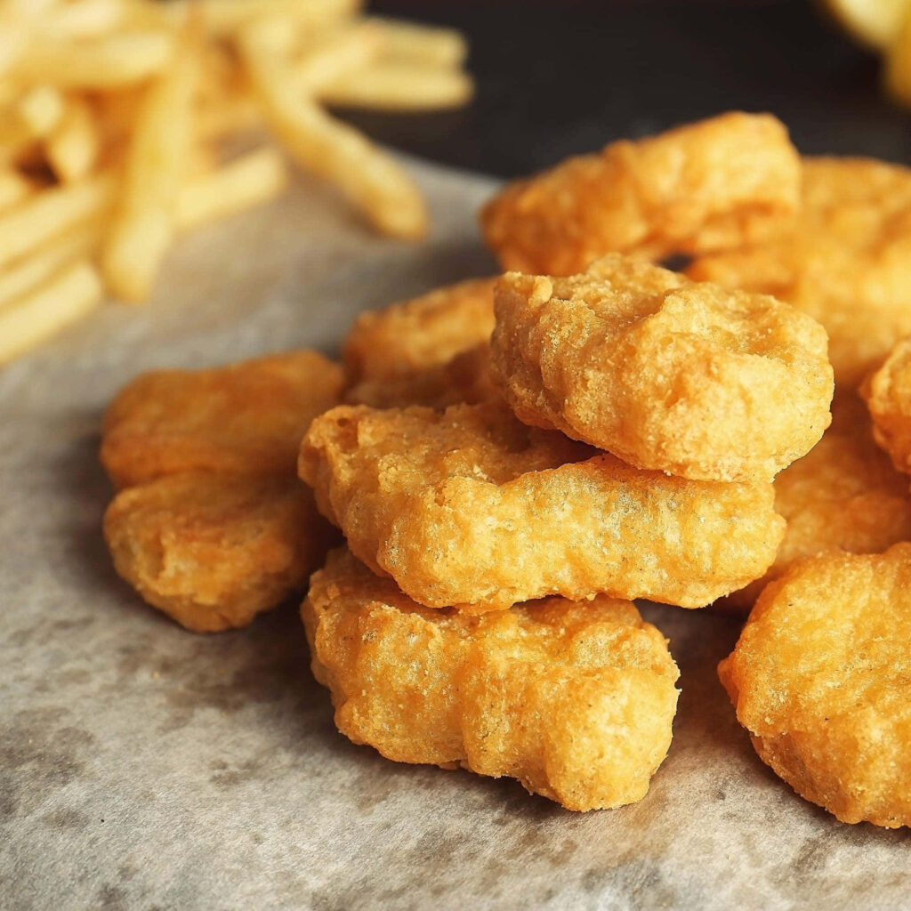 Crispy Golden Chicken Nuggets on Parchment with Fries Wallpaper