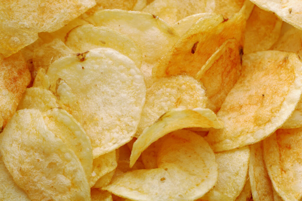 Crispy Golden Lays Potato Chips Close-Up Wallpaper Background