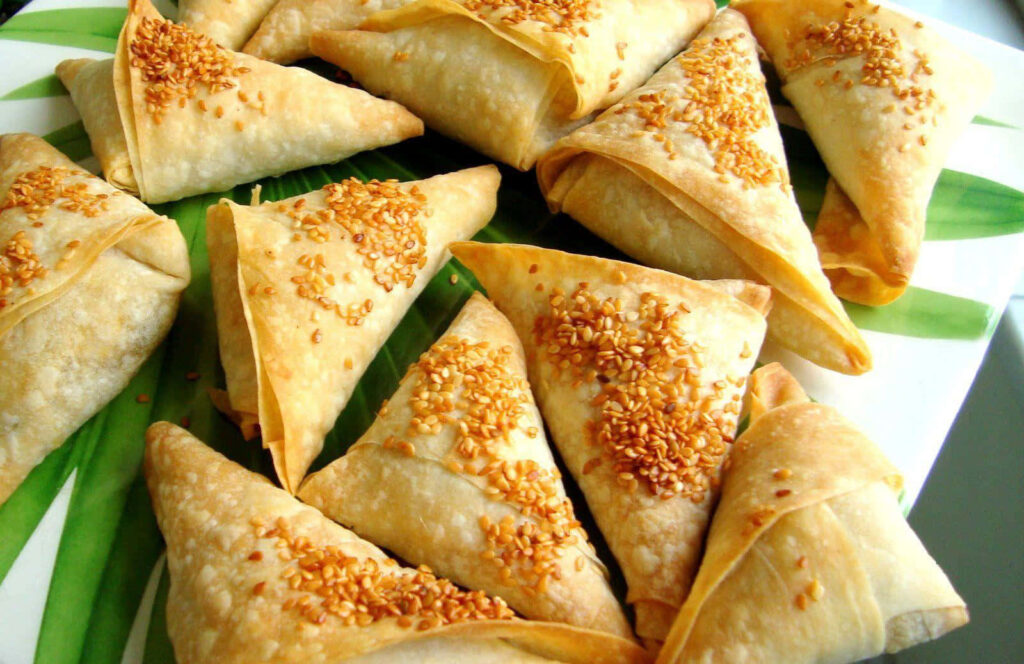 Crispy Indian Samosas Wallpaper: Golden-Brown Delights on Green Platter