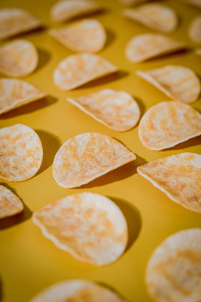 Vibrant Yellow Wallpaper with Crispy Curved Potato Chips Background