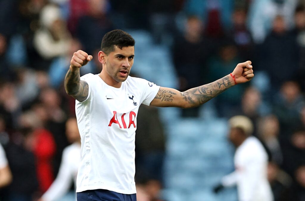 Cristian Romero celebrates victory with fists raised wearing Tottenham Hotspur jersey stadium backdrop Wallpaper
