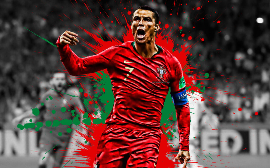 Cristiano Ronaldo in red Portugal jersey celebrating with vibrant red and green paint splashes background Wallpaper