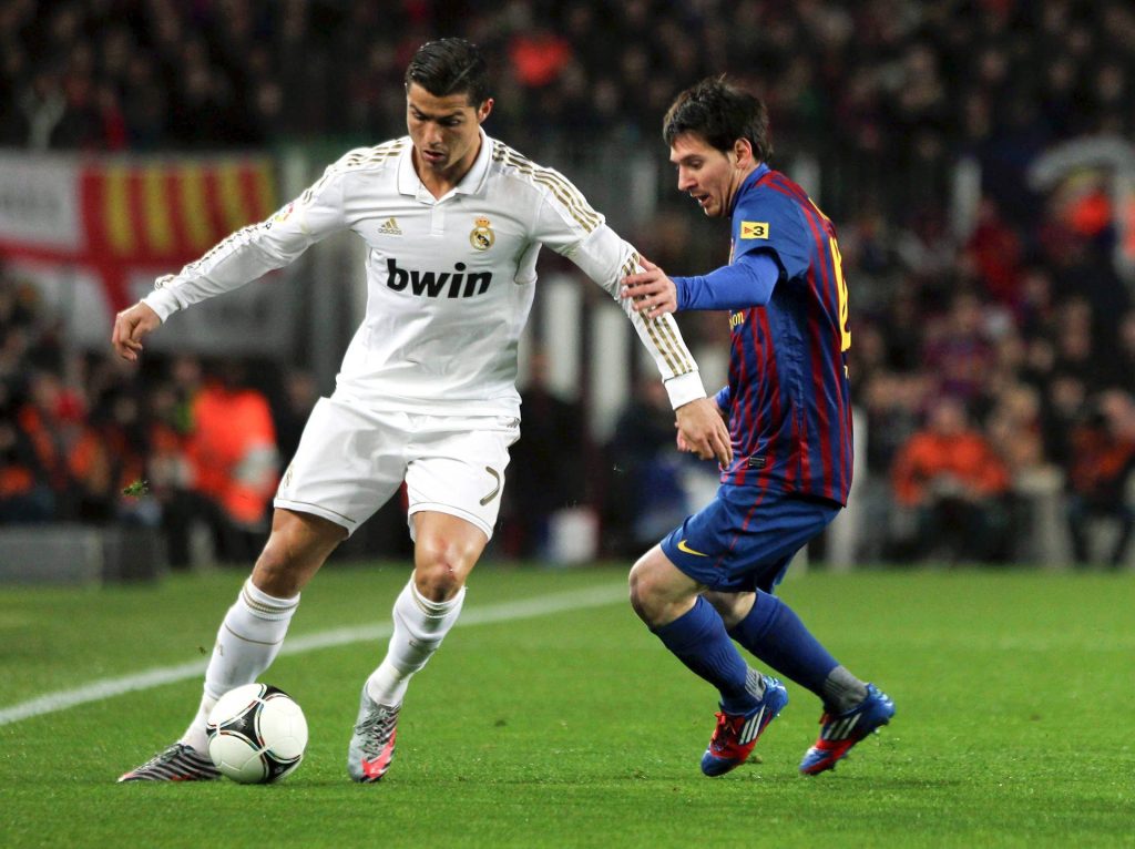 Cristiano Ronaldo Real Madrid dribbling past Lionel Messi Barcelona intense football rivalry wallpaper