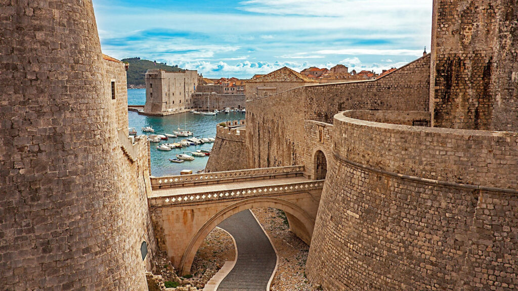 Stone walls and historic Croatian castle with sea views and old town rooftops wallpaper background