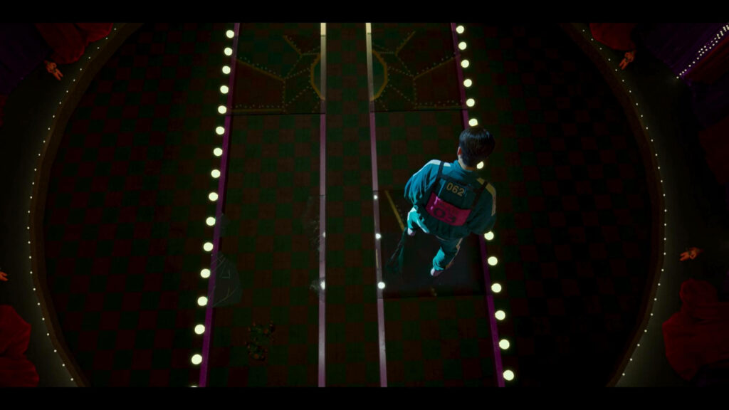 Player 062 on Glass Bridge Squid Game QHD wallpaper with glowing lights suspenseful scene