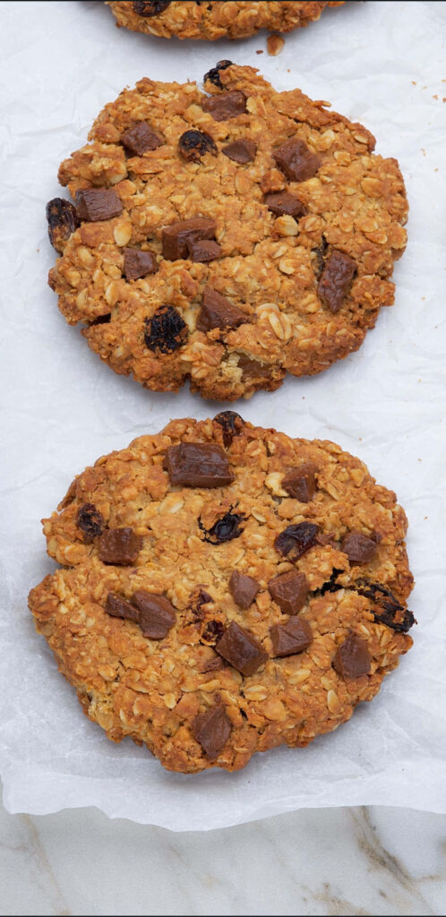 Crispy Goodness: Close-up of Chunky Oatmeal Raisin Cookies on a Soft Canvas Backdrop Wallpaper