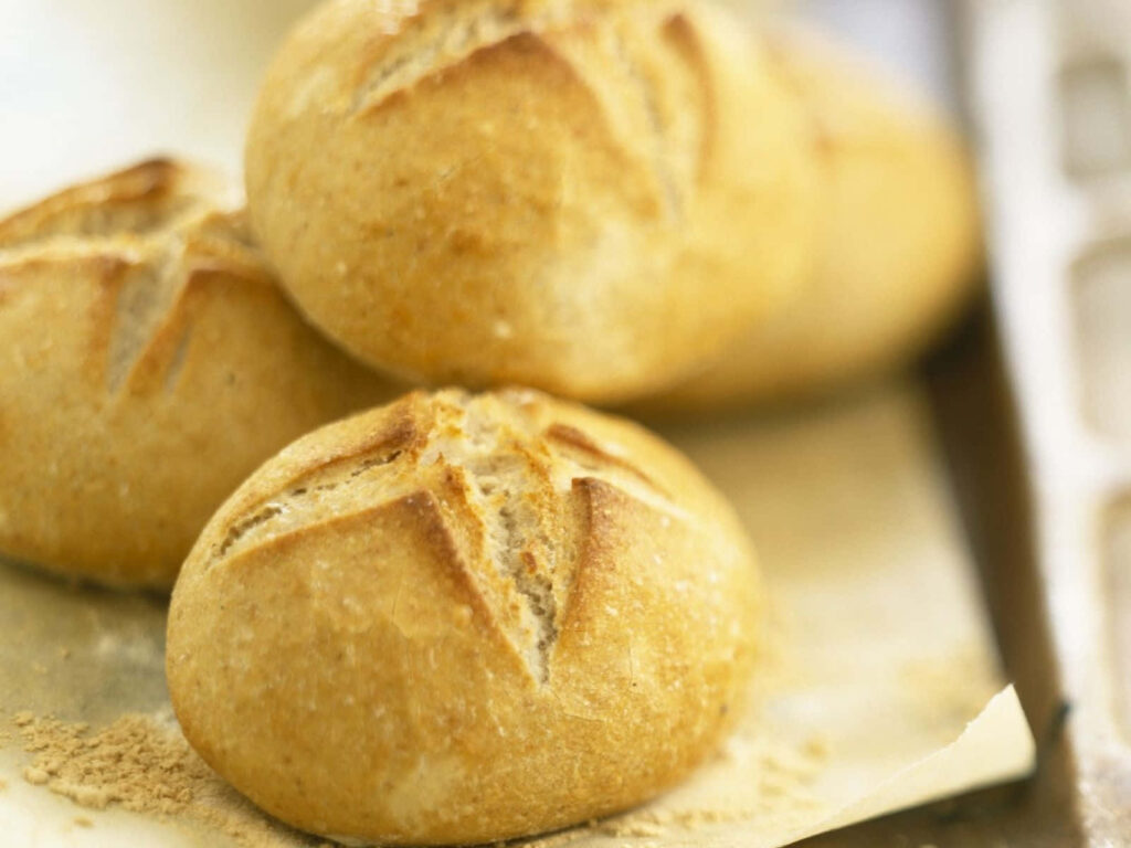 Golden brown star-shaped artisan bread rolls with rustic textures and warm bakery colors wallpaper