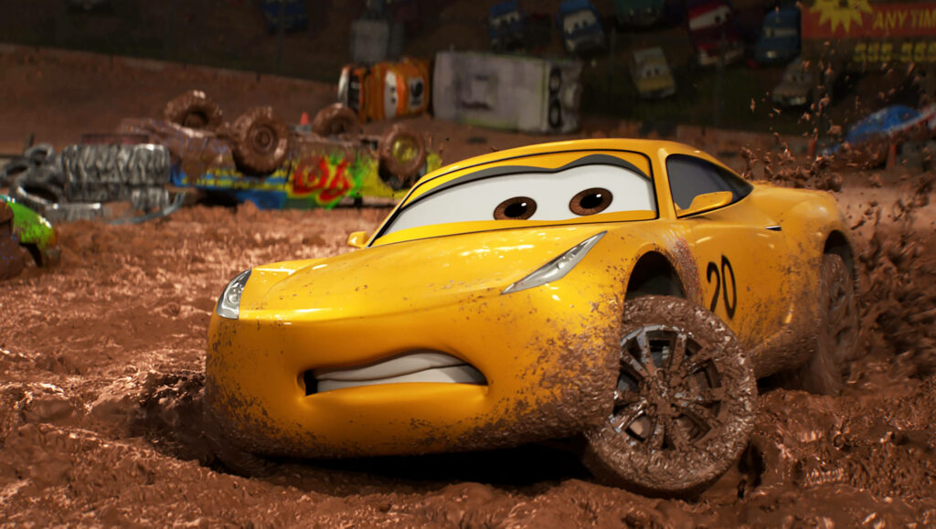 Cruz Ramirez racing on muddy track in Cars 3 wallpaper showcasing speed and determination