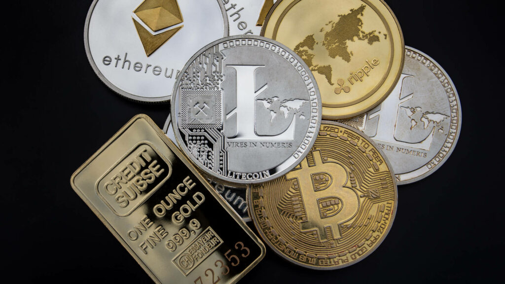 Close-up of Bitcoin Ethereum Litecoin Ripple coins and gold bar on sleek black crypto wallpaper background