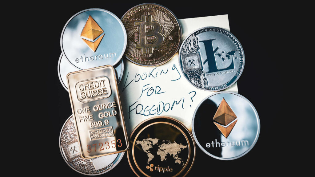 Cryptocurrency coins and gold bar with Looking for Freedom note on dark modern wallpaper background