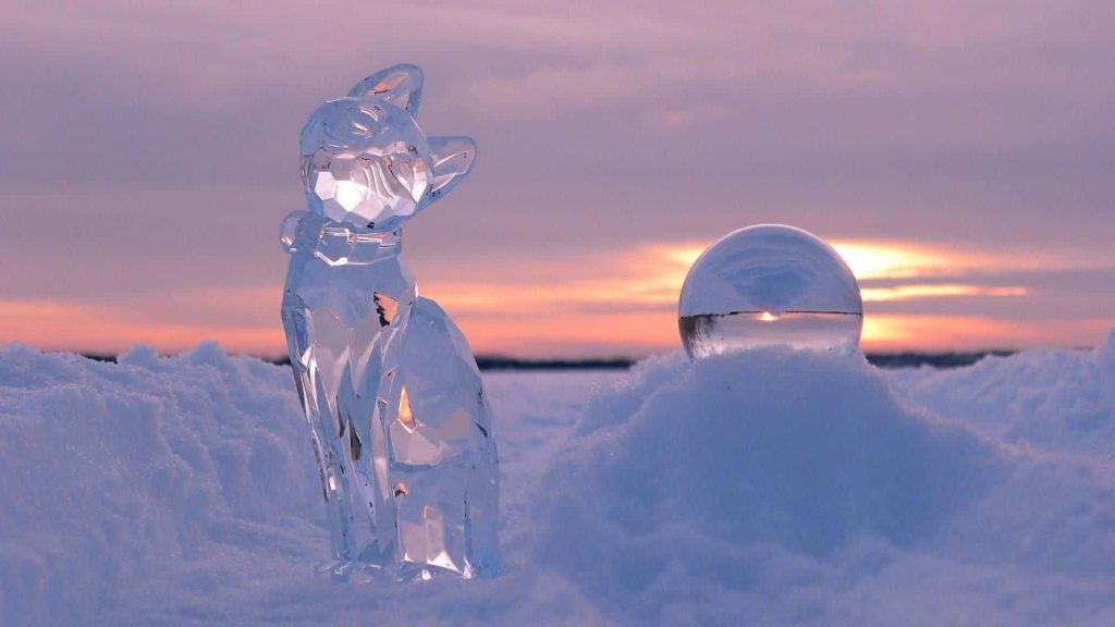 Faceted crystal cat ice sculpture in deep snow with glass lensball reflecting pastel sunset Wallpaper