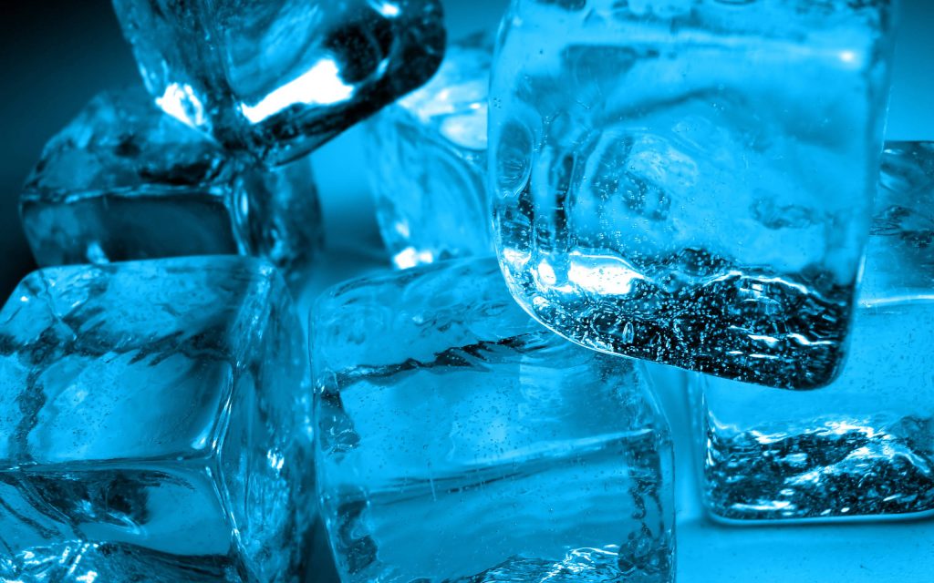 Close-up of stacked translucent ice cubes glowing vibrant blue with detailed air bubbles macro wallpaper